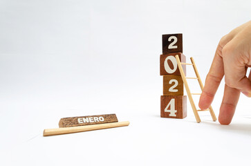 Dedos construyendo el año nuevo 2024 con escalera de madera. Proyección, ideas y propósitos para...