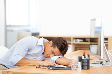 Businessman, sleeping and computer on desk at office in fatigue, burnout or mental health. Tired man or employee asleep or taking a nap in relax or rest sitting on chair or table by PC at workplace