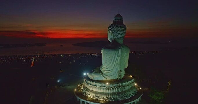 ..aerial view stunning red light in twilight in front of Phuket big Buddha..The sun's rays illuminate the Buddha's serene making it .stand out against the backdrop of sky and creating a stunning image