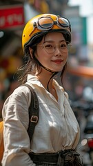 Asian girl grinning and wearing a helmet while holding a smartphone discuss business while riding a bicycle to the office.