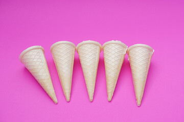 Empty crispy waffle ice cream cones isolated on pink background. Concept, part of pattern of ice creams in cone shape. Snack and dessert. copy space for text.                     