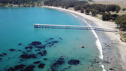 Drone aerial photo of the California coastline with cliffs and rocky beach side coastline in San Simeon pier
