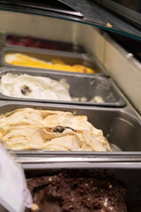Variety of Italian ice cream on display in a refrigerator in a cafe window