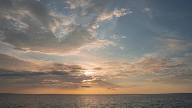 Beautiful pink sunset with sun rays over sea bay. Demonstrating the color of 2024 Peach fuzz