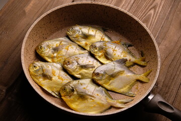 white pomfret fish in a frying pan. White pomfret or silver pomfret is a species of butterfish that lives in the western Indo-Pacific. Pampus argenteus. bawal putih.