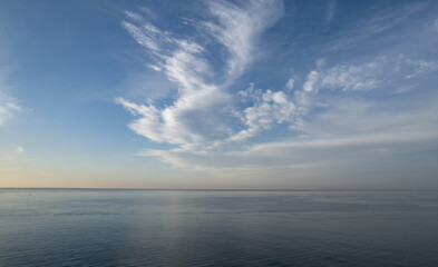 Sea with turquoise clear blue water and blue sky with white clouds. Seascape in winter