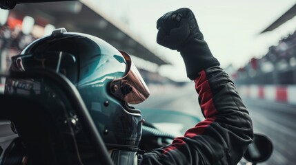 Driver of a racing car raises his arms in victory