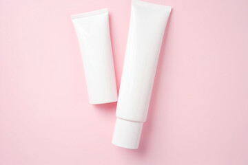 Beauty levitation concept with cream tube, jar and serum on pink background, top view, flat lay,