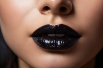 Fototapeta premium Close-up of beautiful lips with black lipstick