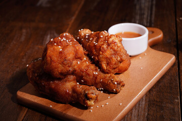 Crispy grilled chicken thighs and sauce on a wooden table