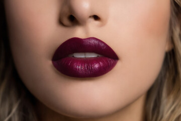 Fototapeta premium Close-up of beautiful lips with bordeaux lipstick