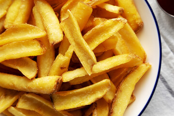 Homemade French Fries on a Plate on a white wooden background, top view. Close-up.