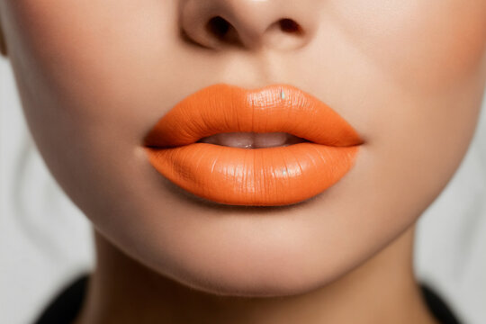 Close-up of beautiful lips with orange lipstick
