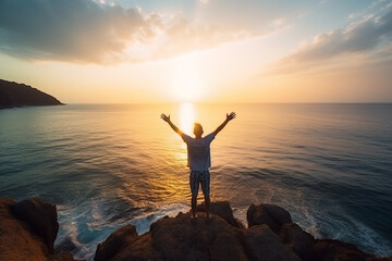 Fototapeta premium Standing on mountain peak arms raised in success