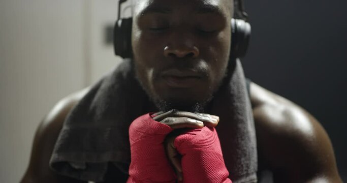 Black man, hands and fighter getting ready for boxer, competition or training at night, club or gym. Closeup of African male person, athlete or boxing with fist gloves for fight, MMA or self defense
