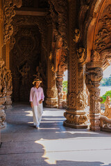 Asian women visit The Sanctuary of Truth wooden temple in Pattaya Thailand, sculpture of Sanctuary of Truth temple. 