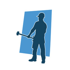 Silhouette of a worker in action pose using his sledge hammer tool.