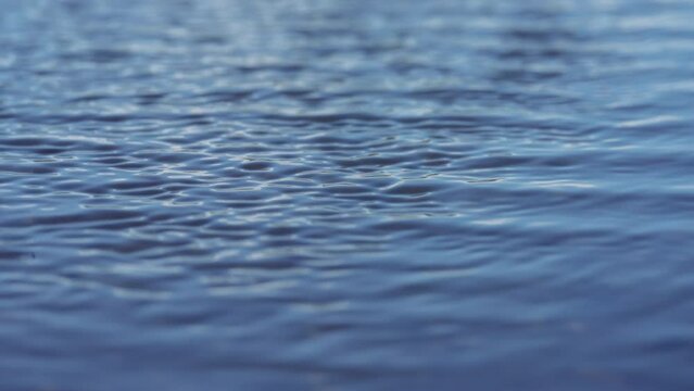 Wind ripples on the blue water surface. Slow motion. 