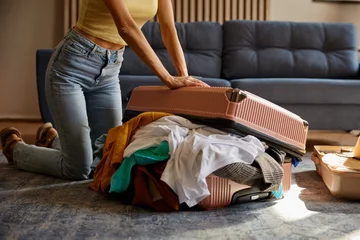 Foto op Aluminium Young woman trying to close luggage bag with excess of clothes © Nomad_Soul