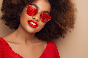 Beautiful portrait of an African girl in sunglasses in the shape of hearts. Valentine's Day. Symbol...
