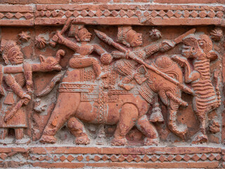 Closeup view of carved terracotta hunting scene of hunters on elephant  killing tiger on ancient...