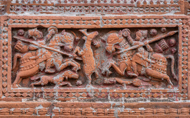 Closeup view of carved terracotta hunting scene of hunters riding horses chasing deer on ancient...
