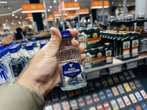 Frankfurt, Germany - Nov 10, 2023: A customer holds a bottle of Vodka Gorbatschow in a German supermarket, showcasing a popular alcohol selection in a retail environment