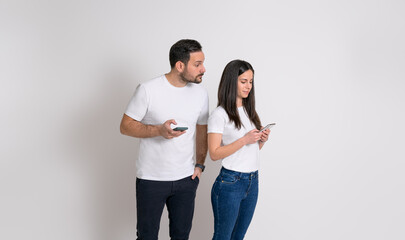 Jealous man peeking into girlfriend's cellphone and trying to read her messages on white background