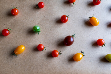 Cherry tomatoes are scattered on the table. Tomato background for publication, design, poster, calendar, post, screensaver, wallpaper, postcard, banner, cover, website. High quality photo