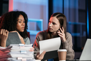 Businesswoman sitting and working hard at with front of computer and lots of documents on the table in workplace at late with serious action, Work hard and too late connect