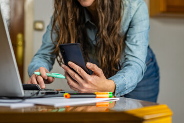 Woman Performing online transactions with laptop and smart phone.