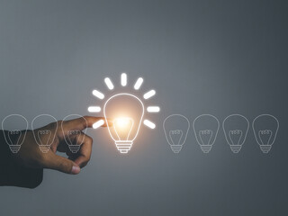 A bright light bulb, a new idea, a new way of working. creative concept On another dark bulb