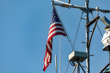 The great American flag, flying on the flagpole of an American ship, from where it is sighted...