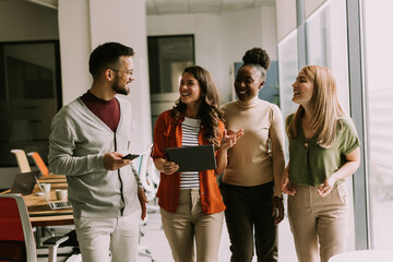 Young multiethnic startup team walking in the modern office