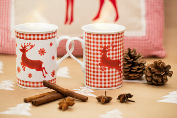 Christmas composition – mugs with deer motive, cinnamon sticks, anise and pinecones.