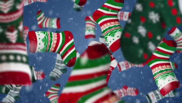 Multi-colored socks with Christmas ornaments on the blue sky background fall down.