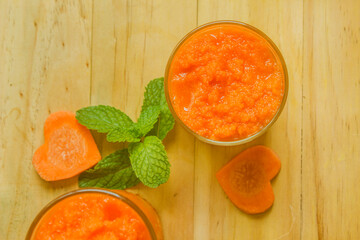 Carrot smoothie, healthy drink in glass, top view