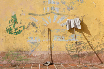 Cleaning utensils on a wall of Trinidad in Cuba