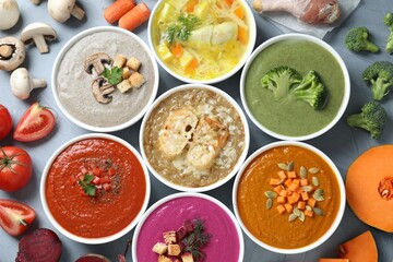 Tasty broth, different cream soups in bowls and ingredients on table, flat lay