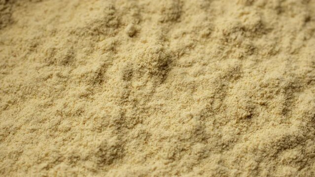 Zoom frame ground ginger powder close up. Condiment or dietary supplement