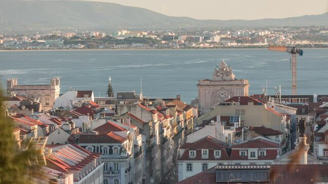 Aerial view of Lisboa downtown timelapse during sunset. Panoramic of Baixa, Rossio and Chiado red rooftops from above. Arch on the Augusta street. Almada on the other side of Tejo river. Portugal