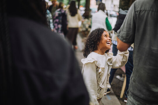 Cheerful daughter having fun with father at flea market