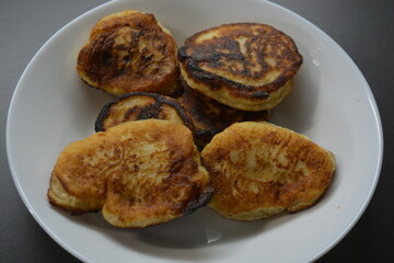 Morning breakfast, fresh, warm pancakes placed on a white, glass plate.
