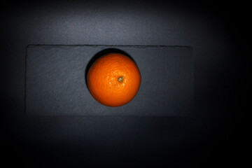 Round orange on a black background, orange for juice, citruses