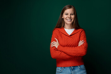 Successful Caucasian woman with brown hair wearing a red sweater on a green background