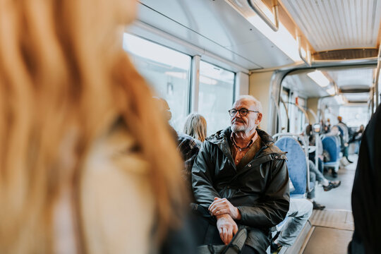 Contemplative male owner sitting in bus while traveling to work