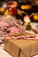 Christmas gift packed with recycled paper and twine. Christmas decoration on white wooden table