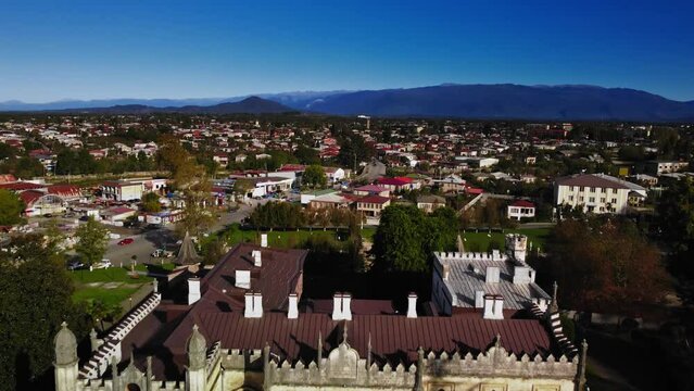Zugdidi, Georgia: Amazing Caucasus town with old architecture and mountains on the background captured by drone. Aerial scenery with charming houses and famous Dadiani palace surrounded by green lawn.