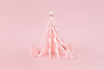 Pink origami Christmas trees. Monochrome winter holidays background.