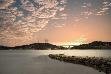 Landscape shot on a coast in winter with a view of the Tjörnbron cable bridge in the bay of...